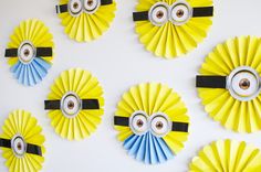 several yellow and blue paper fans with eyes on them are arranged in the shape of minion faces