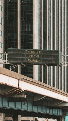 a street sign that says think good for the journey on it's side in front of a tall building