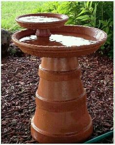 four different pictures of an outdoor fountain with flowers in the back ground and on the side