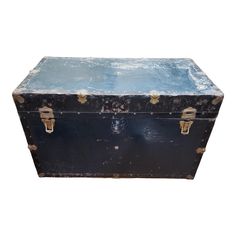 an old black trunk with brass handles on a white background