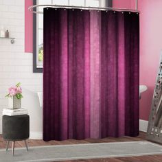 a bathroom with pink and purple shower curtain in the corner, white bath rug on the floor