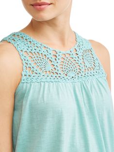 a woman wearing a blue top with crochet on it