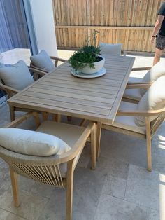 a table and chairs with a potted plant on top