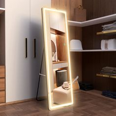 a large lighted mirror sitting on top of a hard wood floor next to a closet