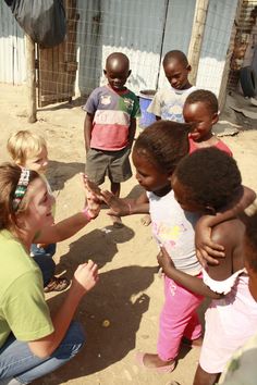 a group of young children standing next to each other in front of a fence and building