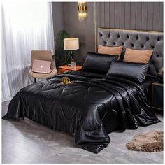 a bed with black sheets and pillows in a room