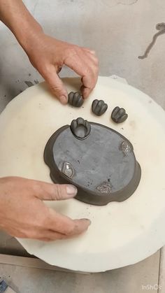 a person is working on an object that looks like a piece of art with two hands