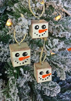 three snowman ornaments hanging from a christmas tree