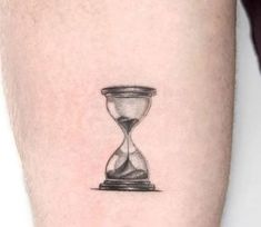 a small hourglass tattoo on the arm