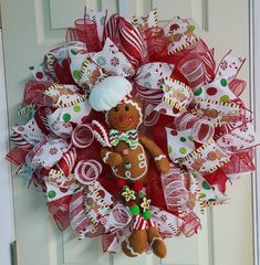 a christmas mesh wreath with a gingerbread man and candy canes on the front door