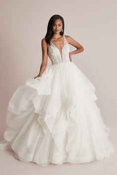 a woman in a white wedding dress posing for the camera with her hands on her hips