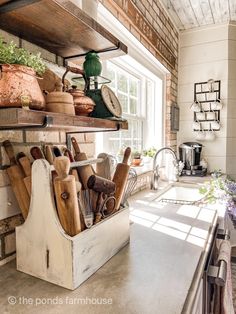 a kitchen filled with lots of pots and pans on top of a counter next to a window