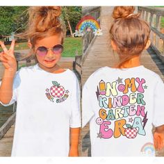 In My Kindergarten Era, Kindergarten Shirt, Kid School Shirt Kindergarten, School Custom Name Shirt, Back To School, Kindergarten Team Tee  ↓ Click here to view our additional fashionable collections ↓ https://handcraftedbyhelenn.etsy.com Product Details: - 100% Cotton (fiber content may vary for different colors) - Medium fabric (5.3 oz/yd2 (180 g/m2)) - Classic fit - Tear away label - Runs true to size Care instructions: - Machine wash: warm (max 40C or 105F); - Non-chlorine: bleach as needed; - Tumble dry: Medium - Do not iron; Do not dry clean ● Please choose your preferred style, size, and color from the dropdown menu or leave us a message in the "notes to seller" section. ● We are committed to processing and shipping your items as quickly as possible, but please note that custom prin Multicolor Tops With Name Print For School Spirit, Multicolor Short Sleeve Shirt With Name Print, Cute Printed White Shirt, Multicolor Custom Print School Tops, Multicolor Custom Print Tops For School, Fun Multicolor Shirt With Name Print, Fun School Tops With Custom Print, Cute Custom Print School Shirt, Cute Tops With Name Print For Teacher Appreciation