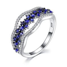 a white gold ring with blue and white stones on the sides, surrounded by diamonds