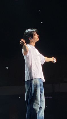 a young man standing on top of a stage holding a remote control in his hand