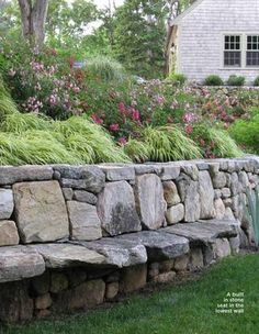 a stone wall in front of a house