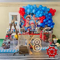 a table topped with balloons and other items on top of a striped cloth covered floor