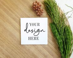 a sign that says your design here next to some green grass on a wooden table