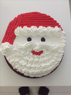 a santa clause cake sitting on top of a white counter next to black and white shoes