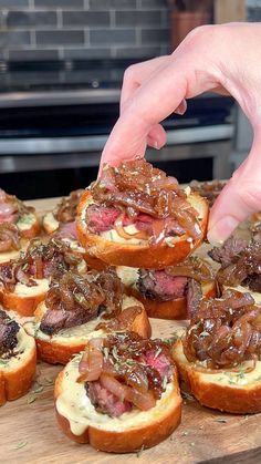 a person picking up some meat on top of bread