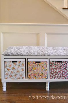 an upholstered bench with drawers underneath the stairs