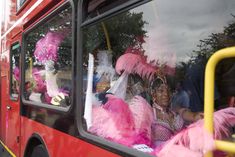 a red bus filled with lots of pink feathers