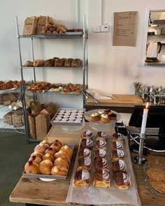 several trays of pastries are sitting on a table in front of the counter