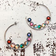 "These earrings are the dream for any cosmic lover! Stunning hoops that make quite a statement! Silver tone with the cosmic images set in the front, and the back is the textured metal. Featuring 7 beautiful nebulae set in such a fashion as to harken to the ROYGBIV of a rainbow. The best part? 10% of the proceeds from this piece get donated to The Trevor Project to help support LGBTQIA+ youth. Makes a great gift, too! Size & Materials: Size: 2 1/8\" x 2\" (5.5cm x 5cm) Earring type: post/stud Multicolor Metal Hoop Earrings, Nickel-free Multicolor Metal Hoop Earrings, Nickel Free Multicolor Metal Hoop Earrings, Handmade Multicolor Metal Hoop Earrings, Pride Earrings, Trevor Project, Lgbtqia Pride, Space Jewelry, Rainbow Items