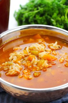 a metal bowl filled with soup and vegetables