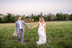 a bride and groom holding hands in a field