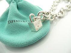 Offered for sale is a wonderful and super cute Tiffany and Co. Sterling Silver 1837 Cube / Box Charm bracelet. The piece is made from substantial and bright Tiffany silver, and yet retains a very feminine feel to it. Attached to its very substantial and bright Tiffany Silver charm bracelet is a super Cool 1837 Cube Padlock charm. The Gift Box padlock charm is permanently attached to the bracelet - so you will not ever have the risk of losing the charm! It is a classic Tiffany piece that will mos Luxury Rectangular Bracelet Gift, Luxury Rectangular Bracelet As Gift, Designer Rectangular Bracelets As Gift, Rectangular Bracelet With Box Clasp For Gift, Rectangular Bracelet With Box Clasp As Gift, Luxury Lock Jewelry For Gift, Luxury Silver Jewelry With Original Box, Designer Silver Jewelry With Original Box, Designer Silver Jewelry In Original Box