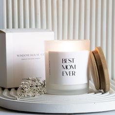 a white candle sitting on top of a table next to a box