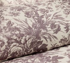 an upholstered fabric with flowers and leaves in purple, white or pink colors