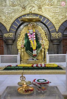 there is a golden statue in the middle of a room with other decorations on it