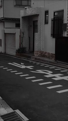 a black and white photo of an empty street with the word stop painted on it