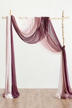 a purple and white drape draped over a wood floor