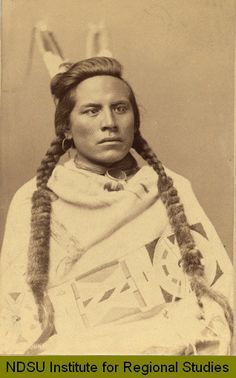 an old black and white photo of a native american woman with braids on her head