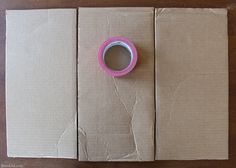 a roll of tape sitting on top of some brown paper next to a hole in the wall