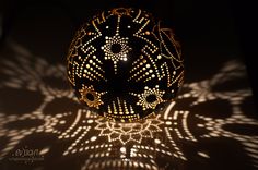 an intricately designed ball is shown in the dark with light shining on it's surface