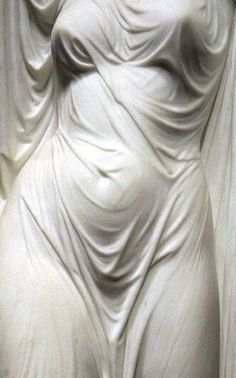 a white statue with flowing fabric draped over it's body and head in the background