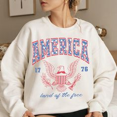 White Custom Print Sweatshirt For Fan Merchandise, White Sublimation Print Fan Apparel Sweatshirt, Patriotic White Cotton Sweatshirt, 4th Of July Graphic Print Crew Neck Sweatshirt, White Custom Print Top For Independence Day, White Independence Day Streetwear Top, White Crew Neck Sweatshirt For 4th Of July, White Long Sleeve T-shirt For 4th Of July, White Long Sleeve T-shirt For Independence Day