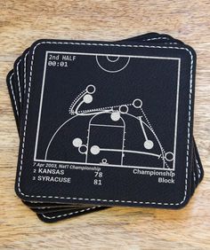 three black coasters with white stitching on them