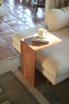 a table with a remote control on top of it next to a couch and coffee table