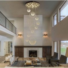 a large living room with two couches and a chandelier hanging from the ceiling