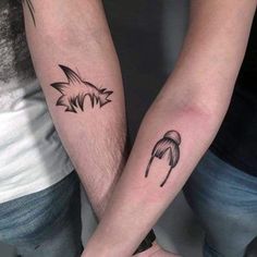 two people with matching tattoos on their arms holding each other's hands and looking at the camera