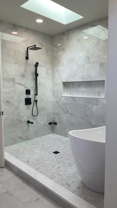 a large white bath tub sitting next to a walk in shower