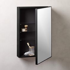 a bathroom cabinet with its door open to reveal a mirror and other items on the shelf