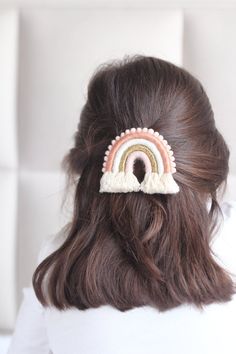 the back of a woman's head with an eye shaped hair clip