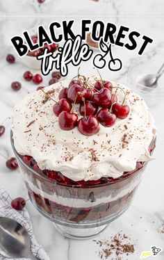 a black forest cake with white frosting and cherries