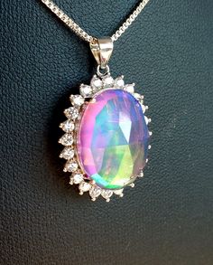 "Gorgeous Rainbow Aurora Opal Necklace, 13x18mm Lab Created Doublet, Rose Cut. See Video For Amazing Colors! 925 Sterling Silver Crystal Halo Pendant, Rhodium Plated. 20\" Sterling Chain.  Gift Box Included. * We Have One Even Bigger!" Rainbow Sterling Silver Round Jewelry, Rainbow Round Sterling Silver Jewelry, Rainbow Colored Round Sterling Silver Jewelry, Elegant Rainbow Pendant Necklaces, Iridescent Sterling Silver Round Pendant Necklace, Iridescent Sterling Silver Necklace With Round Pendant, Dazzling Sterling Silver Oval Pendant Necklace, Oval Silver Jewelry With Shiny Finish, Rainbow Sterling Silver Jewelry For Anniversary